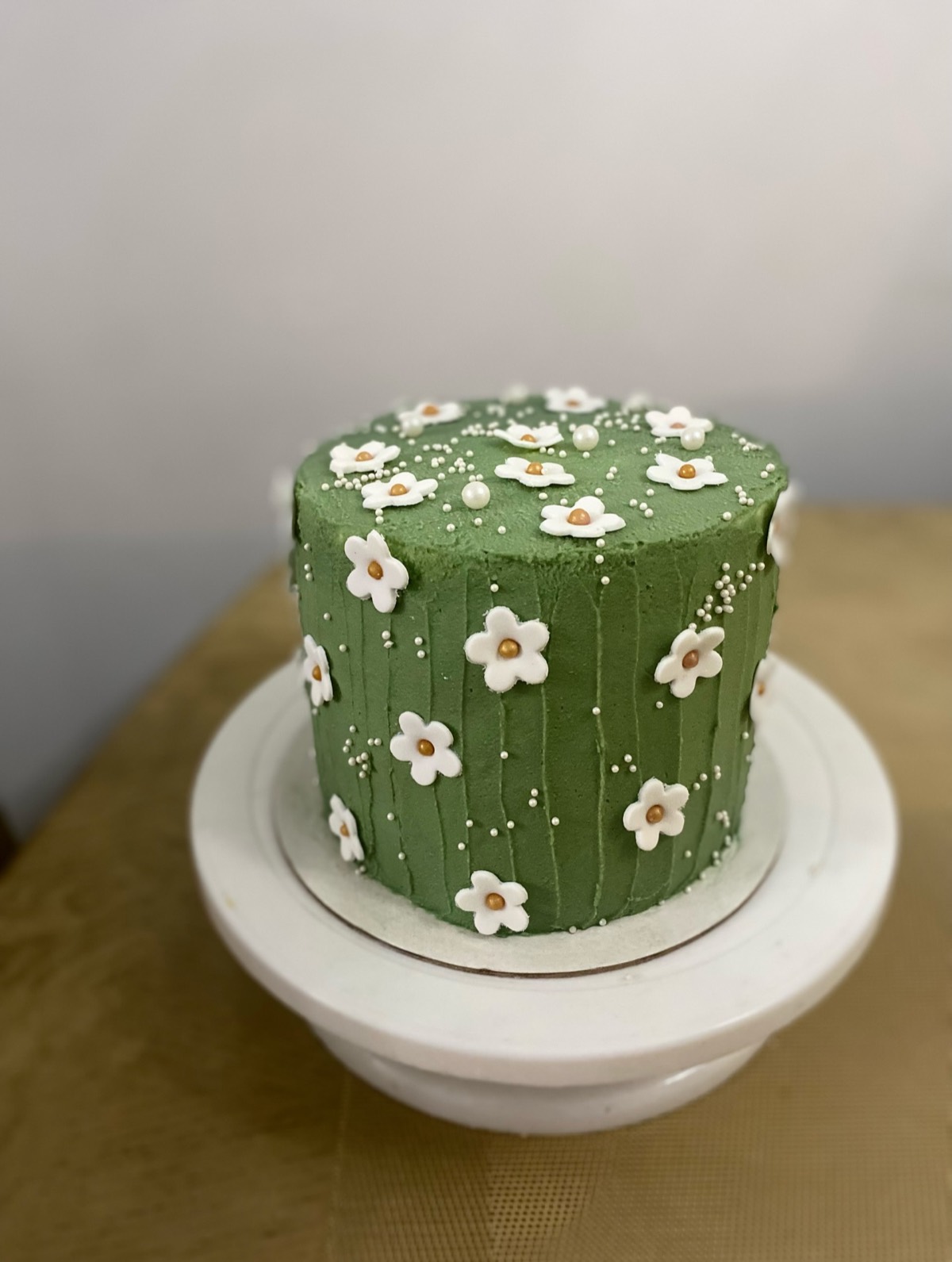 Sage green cake with piped daisies